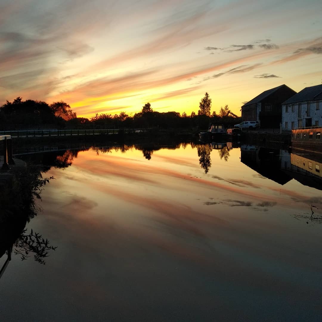 A sunset sky reflecting on the water of the canal